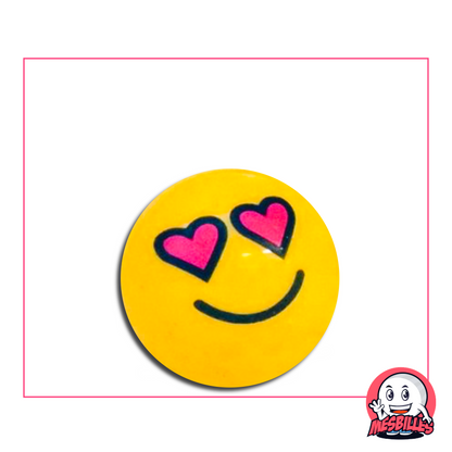 Canica amarilla con una cara con ojos en forma de corazón rosa y una sonrisa dulce