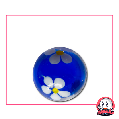 Canica grande azul de 22 mm con una flor blanca de cinco pétalos, fijada en el centro de un cristal transparente